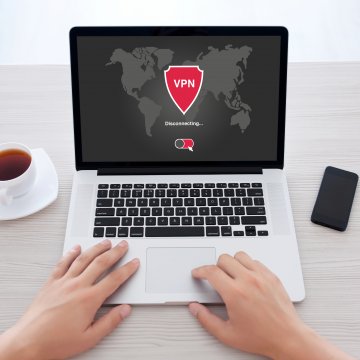 surfshark vpn service hands on laptop cup of coffee